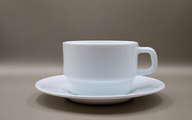 Obraz premium White cup and saucer on neutral background. Minimal clean composition with copy space, ideal for branding, mockups, coffee concepts and modern design.