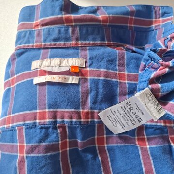Blue and Red Plaid Button Up Shirt Hanging on Neutral Background