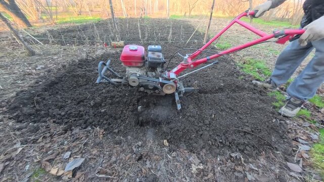 The process of plowing the land with a modern tillerblock on a farm plot