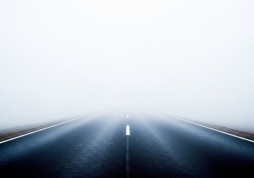 Empty paved road disappearing into a very thick, dense blanket of white fog, emphasizing the isolation and mystery of the cold season, mysterious, surface, desolate