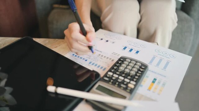 modern women hands marking financial charts with pen during data review paper document financial company statement in office space.