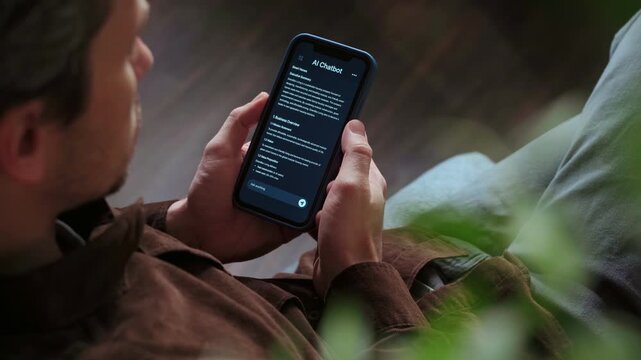 Close up of a man holding a smartphone, using an AI chatbot app for work, brainstorm a business project. Personal Artificial intelligence assistant helping with productivity. Space for text