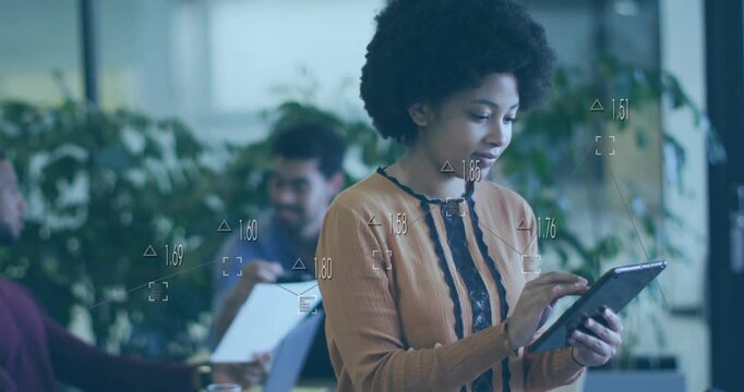 Woman scrolling tablet in open plan office, opening animated business charts for reviewing metrics