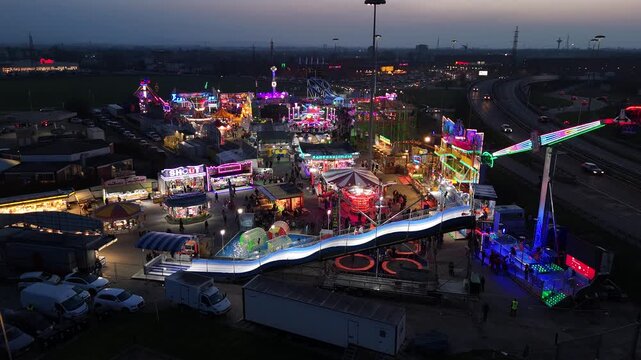 Aerial View of Colorful Amusement Park at Night with Tower Ride and Highway Parma Italy