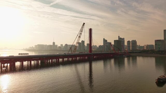 Aerial view of bridge sections being dismantled with a large crane over a river