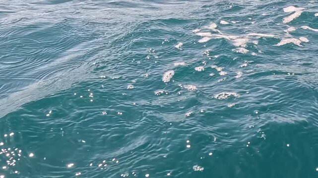 Ocean water splash ripples and foam in the bright sunlight of a tropical sea environment