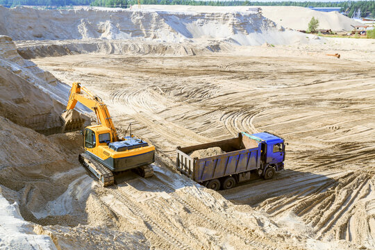 Work of the excavator and truck at a sand quarry.