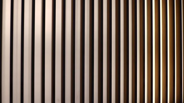 Abstract wooden vertical slats with soft lighting and gradient in slow motion. Suitable for background, interior design, luxury and modern architectural video concepts.