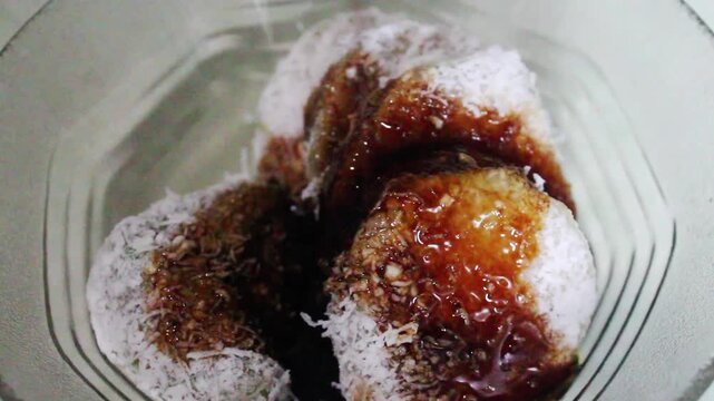 Traditional Indonesian Lupis with Palm Sugar Sauce Pouring Close Up
