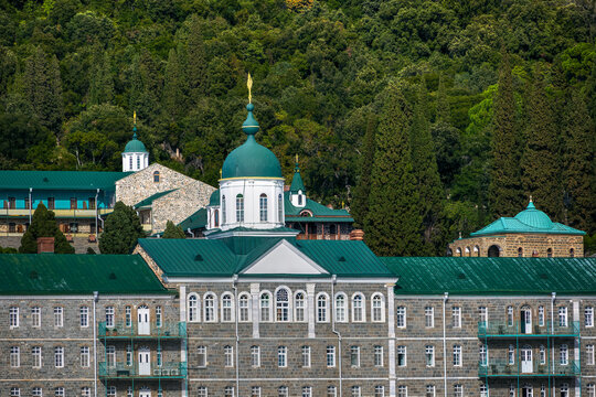 Mount Athos, Agion Oros, Historic monastery of St. Panteleimon complex with green roofs and domes nestled in a dense forest, greece.