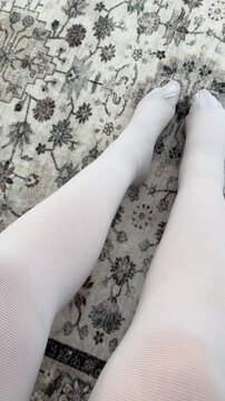 Woman in white compression stockings. Prevention of varicose veins during pregnancy. The texture of the jersey closeup