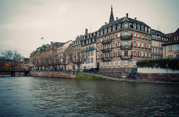 Obraz premium Peaceful Riverside City View. Tranquil Cityscape Showcasing Old Architecture And Reflective Waters