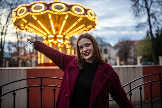 A woman is enjoying herself at an amusement park in the evening