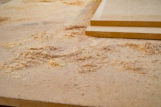 Medium-Density Fibreboard (MDF) panels covered in sawdust after being cut