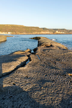 White trachyte rocks and turquoise sea at Cane Malu beach, Bosa, Sardinia, Italy.