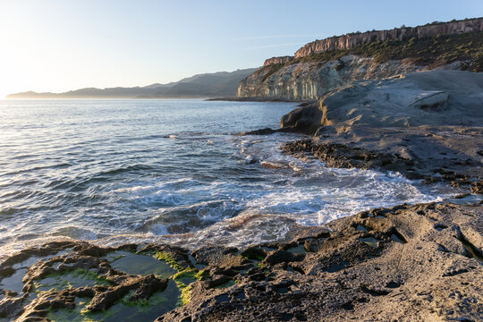 White trachyte rocks and turquoise sea at Cane Malu beach, Bosa, Sardinia, Italy.
