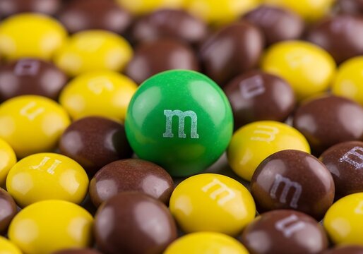 Unique Green MM Stands Out Among Yellow and Brown Candies - Individuality Concept