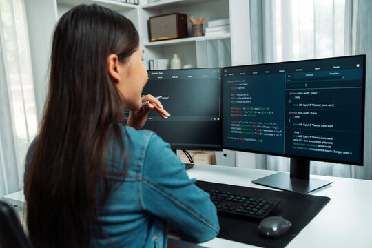 Young Asian IT developer looking online information on pc for beautiful pose with coding program data of website application, wearing jeans shirt. surround by safety analysis two screens. Stratagem.