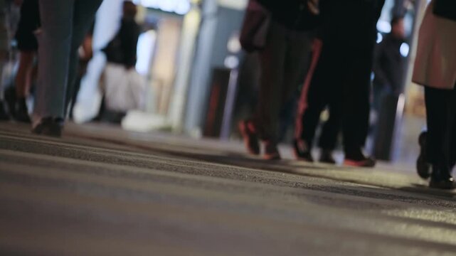 Busy street crossing at night showing footsteps of city pedestrians