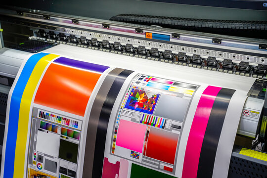Large offset printing press or magazine running a long roll off paper in production line of industrial printer machine.