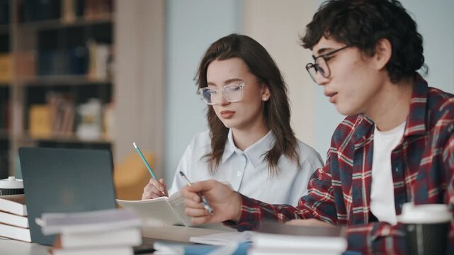 University students collaborating on project in library