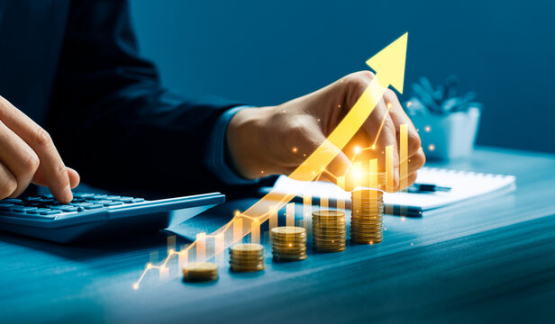 Business professional stacking gold coins while analyzing a financial growth chart with rising arrow on digital interface, representing investment performance, capital growth strategy