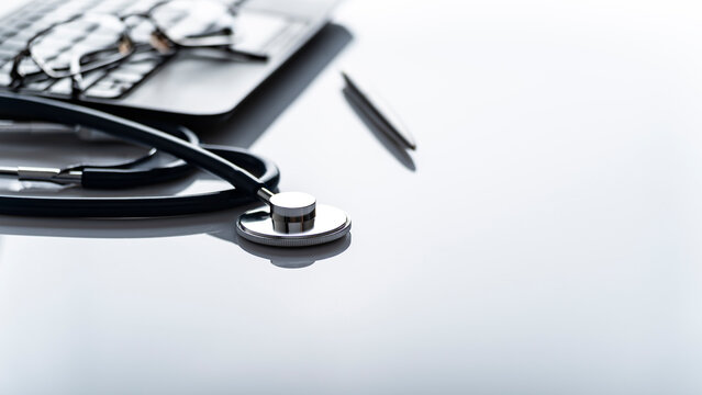 Healthcare background of stethoscope laptop glasses and pen on table with copy-space