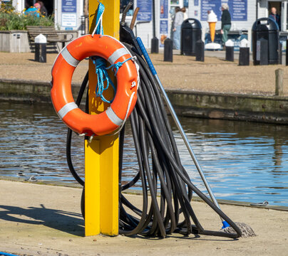 Orange life saver ring and buoyancy aid on the side of the River Thorne in the Potter Heigham, Norfolk Broads