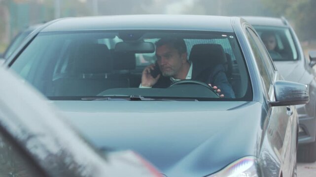 Driver calmly manages traffic stop, Driver interacts peacefully with app during city traffic standstill