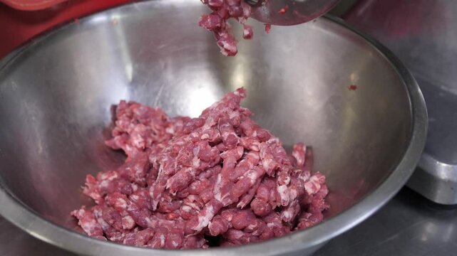 Meat grinder producing fresh minced lamb.
