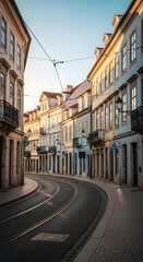 Obraz premium Charming historic European city street curving gracefully with traditional architecture and sunlit tram tracks, evoking a sense of tranquil urban exploration