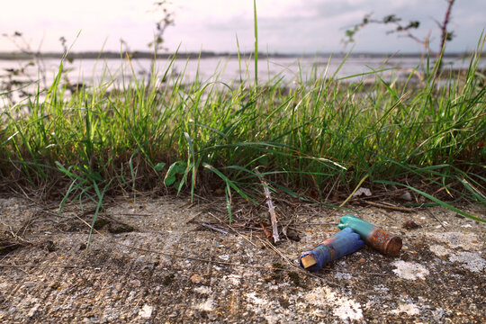 Coastal ecosystem Litter - Shotgun Shells on Sea Wall by Tidal Salt Marsh at Golden Hour