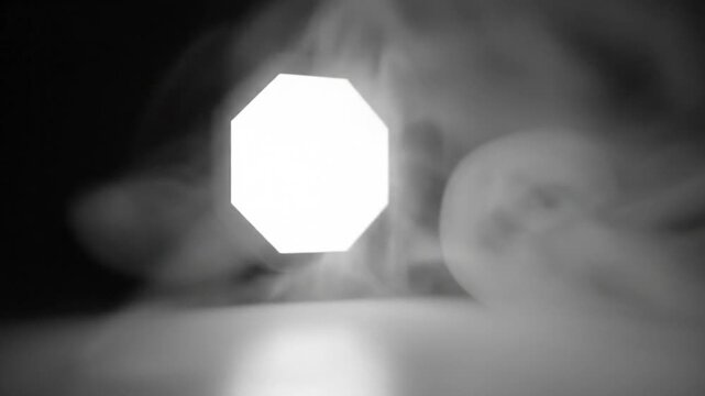 Bright Octagon Light Amidst Wisps of Smoke Creating a Dramatic Atmospheric Effect