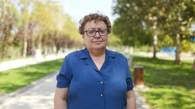Smiling Elderly Woman with eyeglasses Looking at the Camera in a Natural Environment