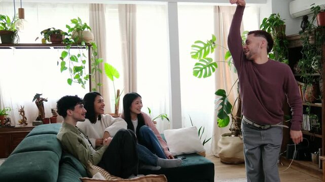 Young diverse friends having fun playing a guessing game together during a home gathering