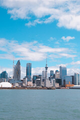 Obraz premium Auckland, New Zealand: A vertical orientation shot of the Auckland city skyline and Sky Tower rising above the blue harbor water