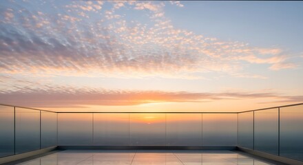 Obraz premium Modern balcony with glass railings overlooking a serene ocean sunset with soft clouds and warm light reflecting on the polished floor