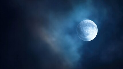 Fototapeta premium A supermoon shines in the night sky, with delicate clouds and cool blue tones, showcasing the details of the moon. Travel magazine.