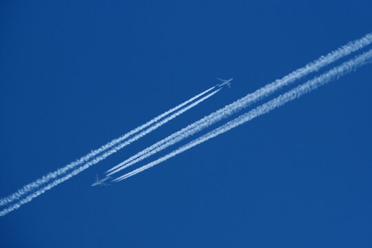 Twin Contrails in Opposite Directions. Two Jets Passing in Opposite Directions with Parallel White Contrails in Endless Blue Sky