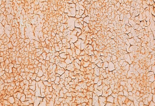 Rusty, pink metallic wall, background. Mangy surface with peeling and heavily cracked paint on rusty background. An old rosy surface with faded crimson color. Scarlet backdrop with peeling paint layer