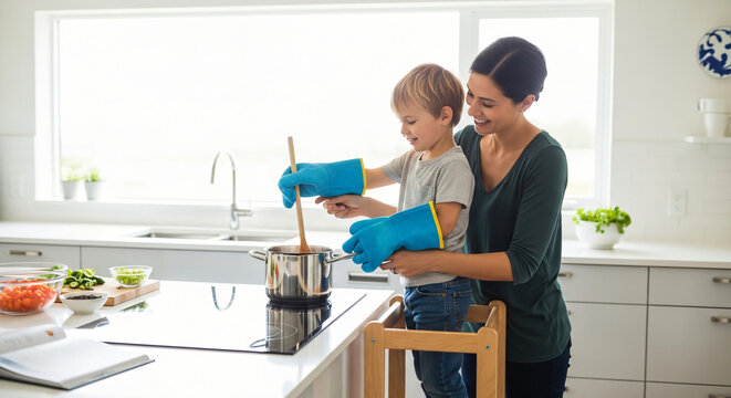 A young child standing on a step stool next to a parent, learning to stir soup on an electric stove, both smiling, bright modern kitchen, safety gloves, warm family moment, lifestyle photography, real
