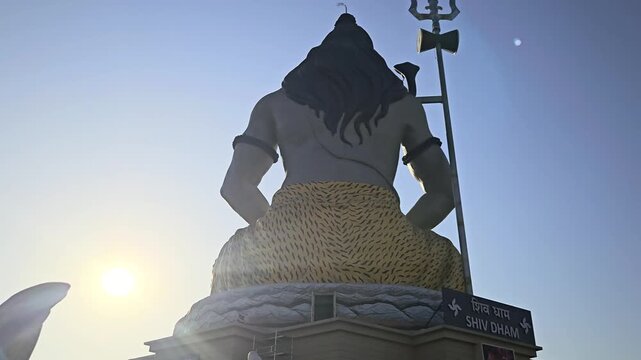 Massive statue of Lord Shiva with trishul at Char Dham Temple in Vrindavan, India, set against a clear blue sky. This iconic spiritual landmark represents meditation, power, and divine energy in Hindu