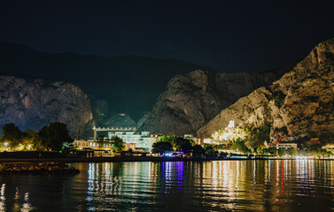 Obraz premium Illuminated Mirabella fortress and mountain cliffs at night in Omis.