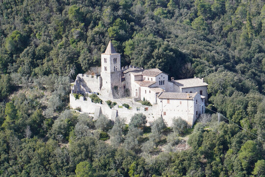 The Benedictine Abbey of San Cassiano near Narni, Umbria, Terni, Italy. The green hills covered by the forest. Distance view. View from the medieval town of Narni. Umbria region, central Italy. 