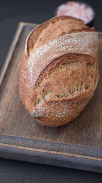 A loaf of homemade whole grain rye bread for the dinner table. A loaf of rye bread as a food background for your design