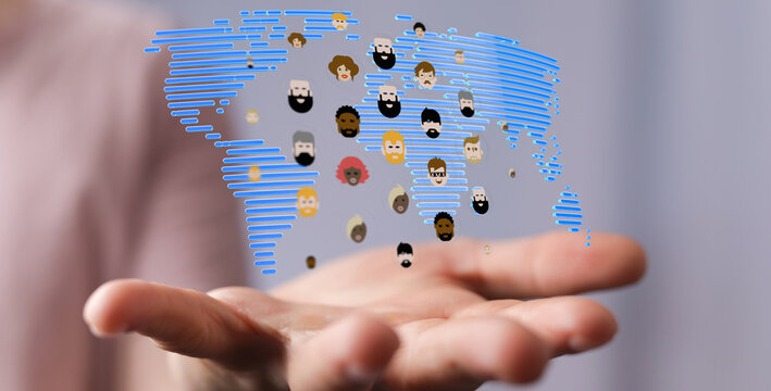 Hand holding a world map with faces representing global unity, community, and diversity. Illustrating concepts like incl