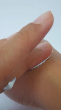 Spreading white sunscreen cream thoroughly and evenly onto the skin surface. Sun protection, UV care, close up view of skincare application for healthy glowing skin.