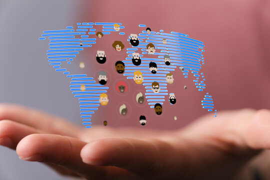 Hand holding world map with diverse faces representing global community and connection, representing unity and social ha