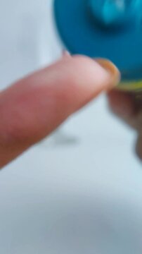 Pouring a small amount of clear cream onto the fingertip. Close up view, skincare or cosmetic product application, smooth texture and precise amount concept.