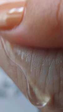 Close up of applying transparent cream on wrinkles with fingers, anti aging skincare for smooth hydrated skin.